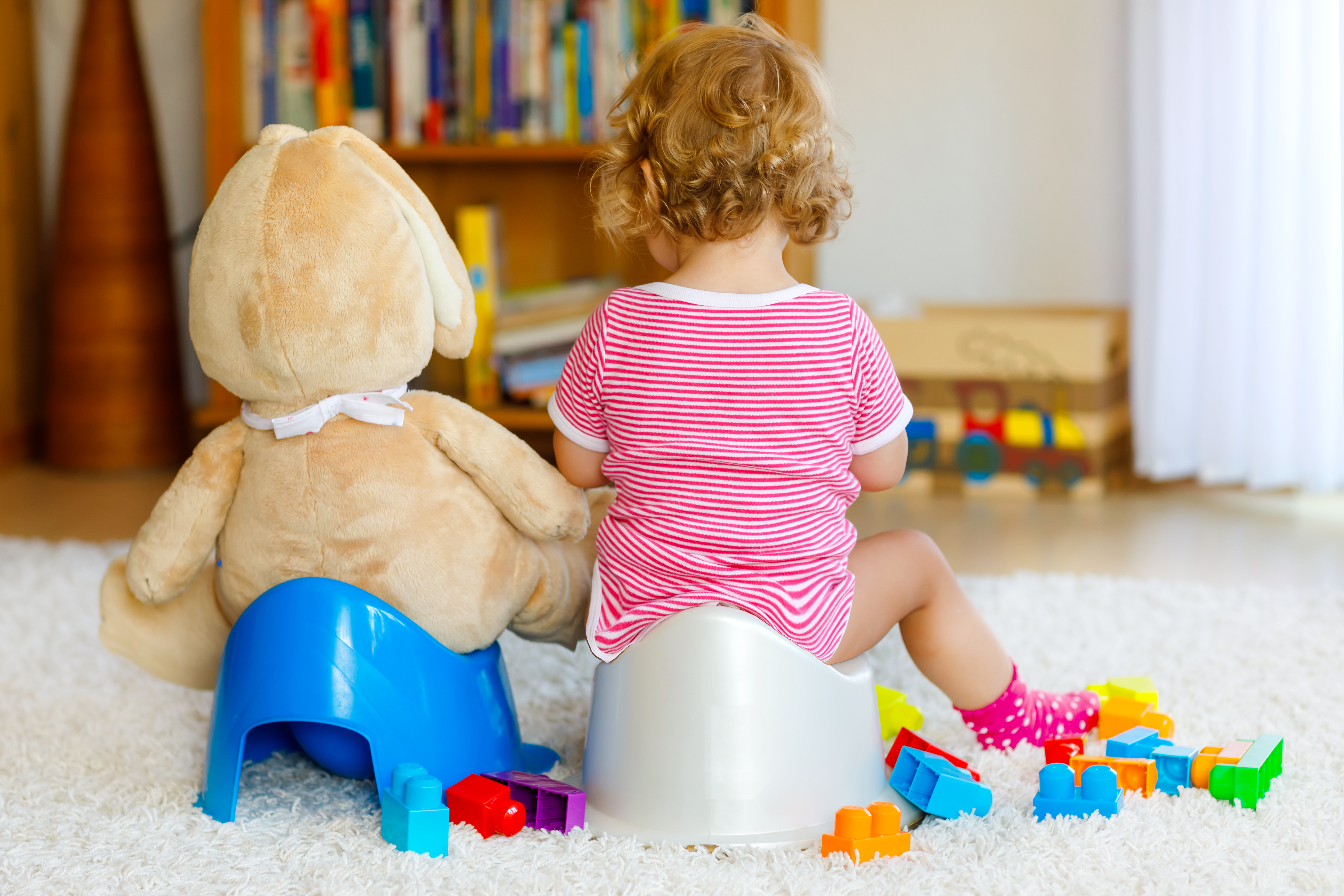 Kind und Teddy auf Töpfchen
